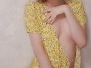 A beauty in a yellow dress poses for the camera and shows off her bubs