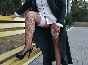 Slut walking in the park in a raincoat and black fishnet stockings with a white elastic band